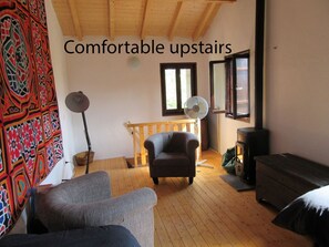 Bedroom / sitting room with pine floor and high beamed ceiling. View of Triora.