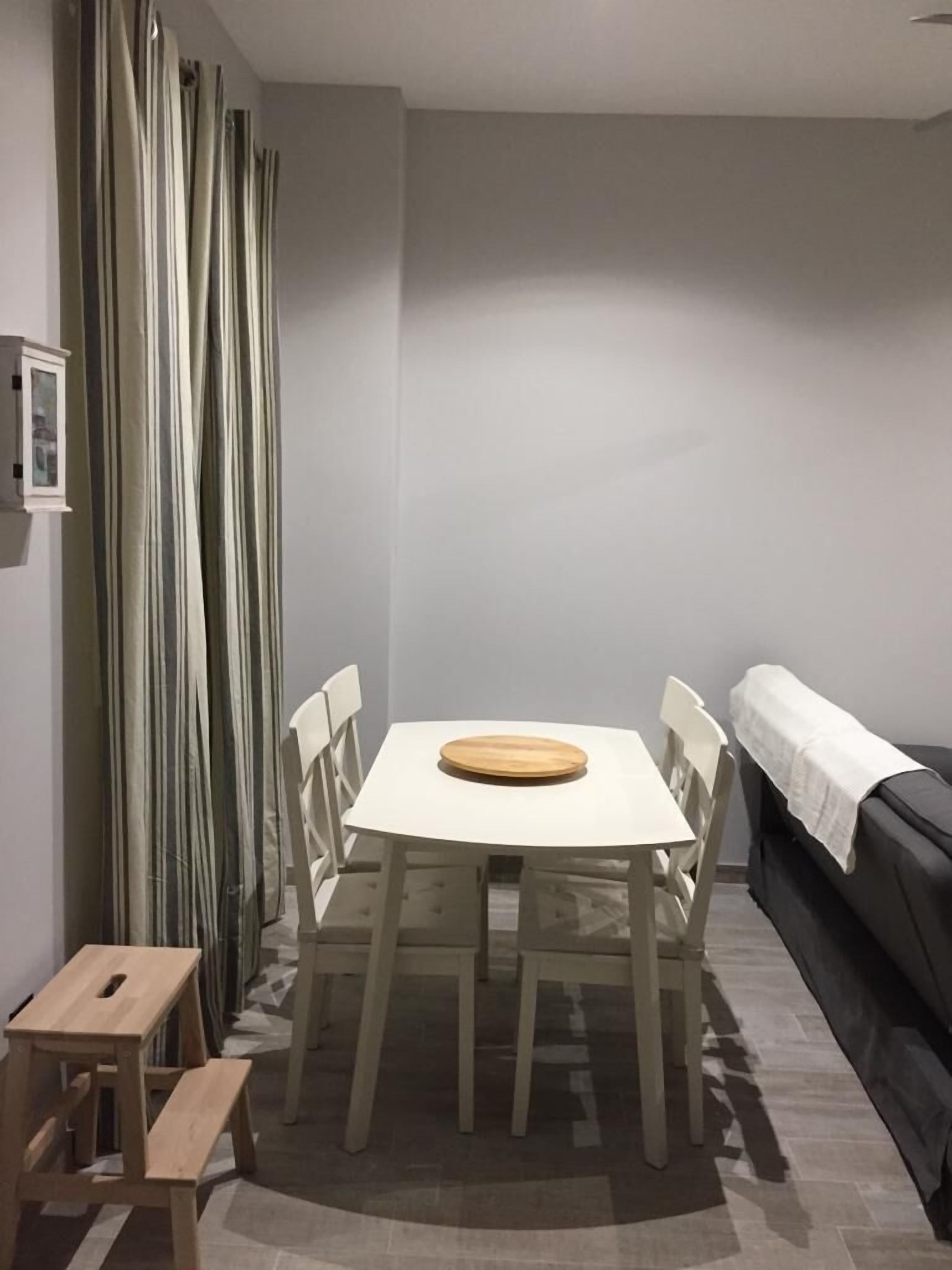 Een intieme eethoek met een tafel en stoelen, een bankje en een bank.