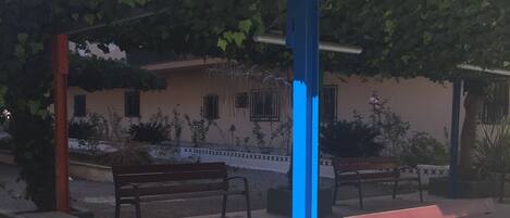 Un espace avec des bancs et une colonne bleue, aménagé dans un parc.