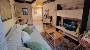 Ein gemütliches Wohnzimmer mit Sofa, Couchtisch, Fernseher und Kamin.