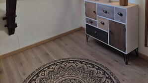 Ein Zimmer mit einer Dachfenster, einem Holzkabinett mit Schubladen, einem Spiegel und einem gemusterten Teppich.