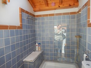 Bañera con ducha, toallas, papel higiénico