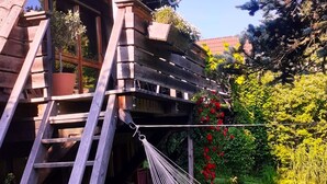 A wooden cabin with a sloped roof, a wooden porch, and a hammock. - Chiemgau, charming chalet with private garden , relax in nature (Siegsdorf)
