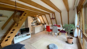 A loft-style living space with a kitchen, dining area, and seating. - Chiemgau, charming chalet with private garden , relax in nature (Siegsdorf)