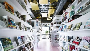 A bookstore with bookshelves on both sides and a central aisle. - MANGA ART HOTEL, TOKYO - Hostel (Tokyo)
