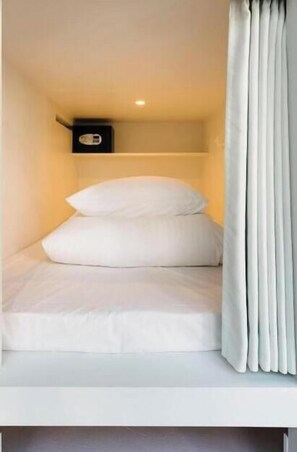 A small, neatly made bed with white bedding in a compact room. - MANGA ART HOTEL, TOKYO - Hostel (Tokyo)
