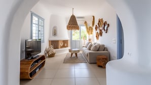 Een moderne woonkamer met een televisie, bank en decoratieve muurkunst.
