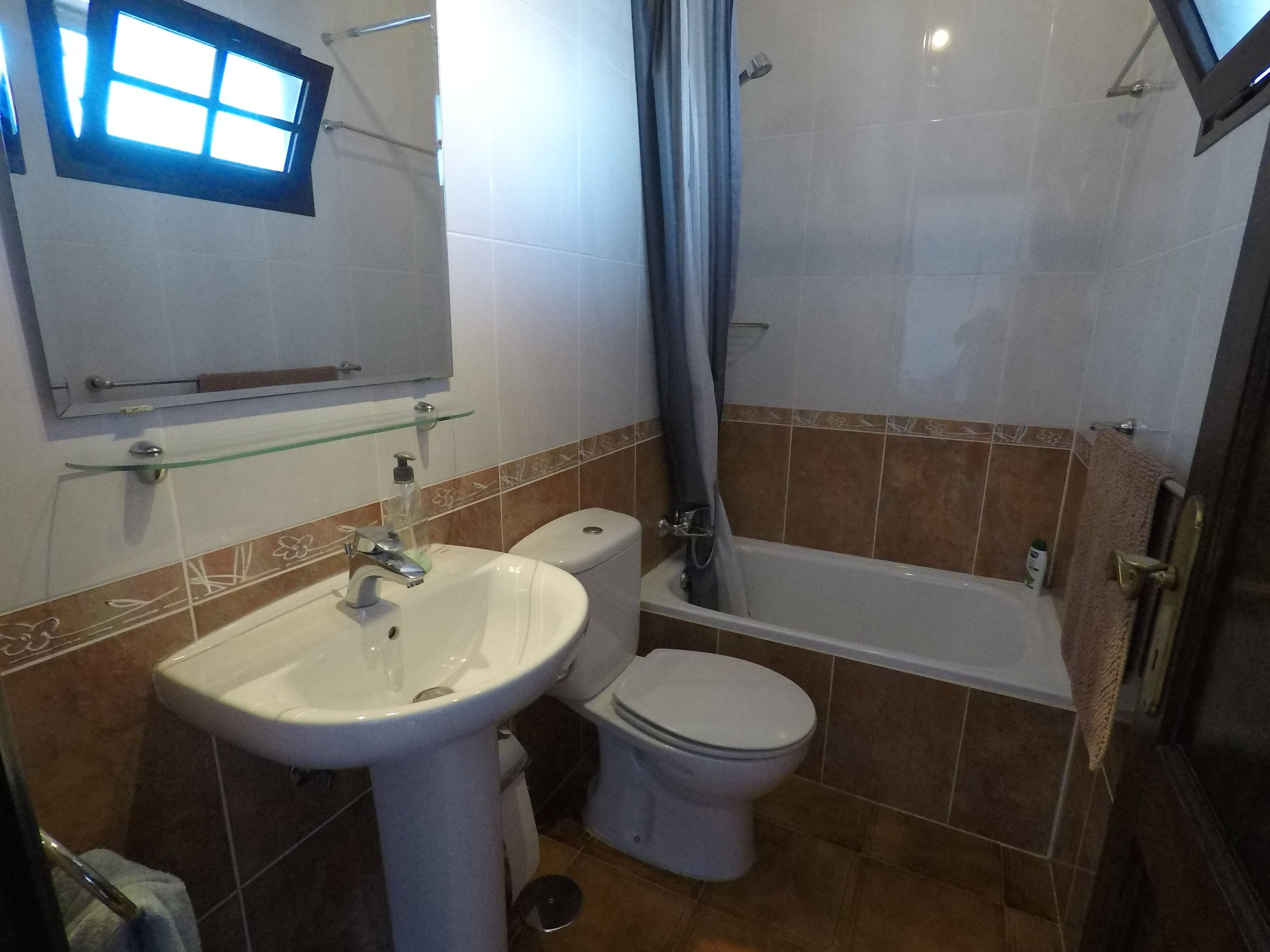 A bathroom with a sink, toilet, and bathtub.