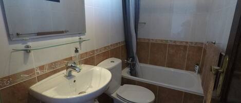 A bathroom with a sink, toilet, and bathtub.