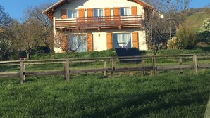 A two-story house with a balcony, surrounded by a wooden fence and lush greenery. - Contemporary cottage between Ubaye and Durance overlooking the lake of Serre Ponçon 2 (Le Sauze-Du-Lac)