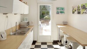 Moderni keittiö, jossa on ruutukuviollinen lattia, mikroaaltouuni, pesuallas ja suuri ikkuna.