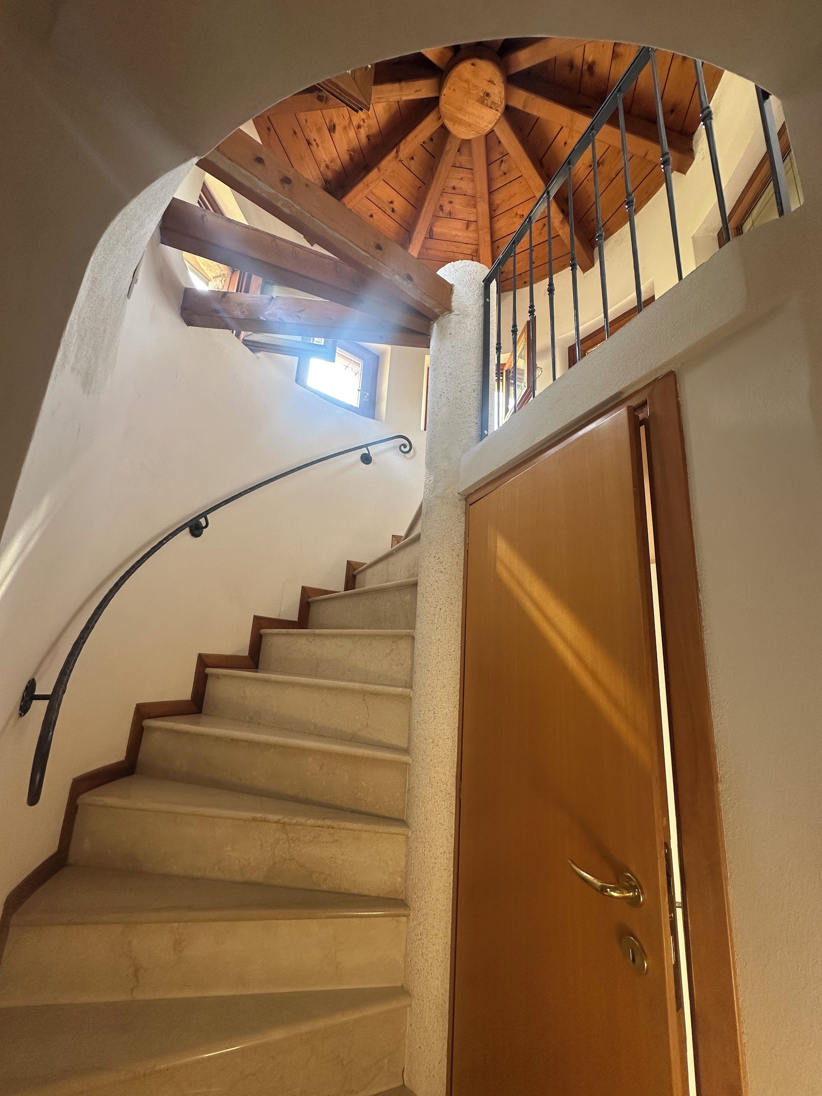 Una escalera de caracol con techo de madera y una puerta al final.