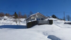 A snow-covered house with a balcony, surrounded by a snowy landscape and trees. - chalet - 4 rooms - 6 persons (La Bresse)