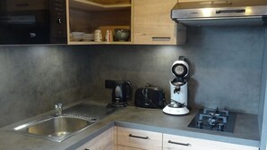 A compact kitchen with a sink, stove, toaster, and microwave. - chalet - 4 rooms - 6 persons (La Bresse)
