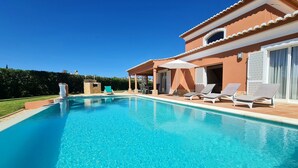 A swimming pool with lounge chairs and a covered patio area. - Beautiful villa with private pool & playground near Lagos & the beach (Vale da Lama)