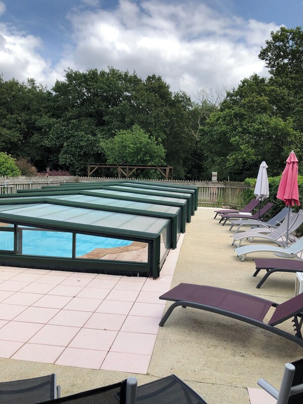 A rooftop pool area with lounge chairs and umbrellas.