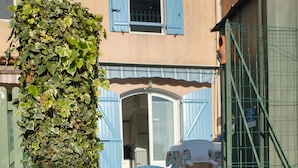 Un cancello blu con un cartello che riporta '25 AJL' e il numero '25' su una parete.