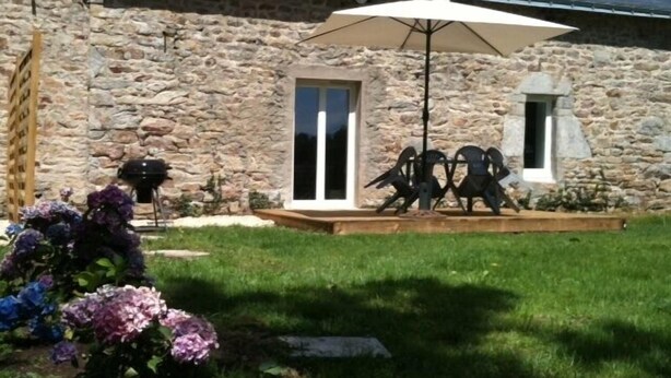 A stone building with a covered patio, a grill, and a statue of birds. -  Lodgings in Vannes (Plescop)