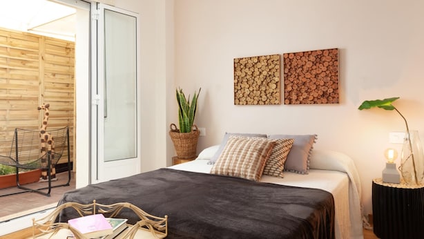 A bedroom with a large bed, a sliding glass door leading to a balcony, and two wall-mounted artworks. - ATTRACTIVE APARTMENT IN COSTA BRAVA (Tossa de Mar)