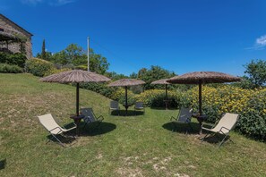 Un espace extérieur aménagé avec des parasols en chaume et des chaises de jardin.