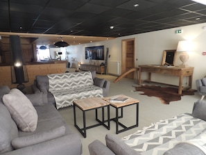 Ein moderner Loungebereich mit Sofas, einem Couchtisch und einem Holzbüro.