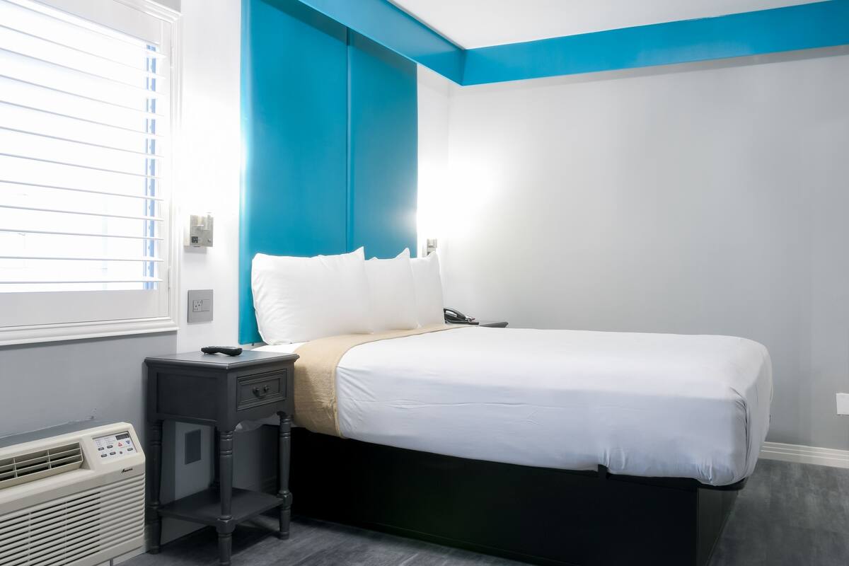 Une chambre à coucher avec un lit, une table de chevet et un radiateur.