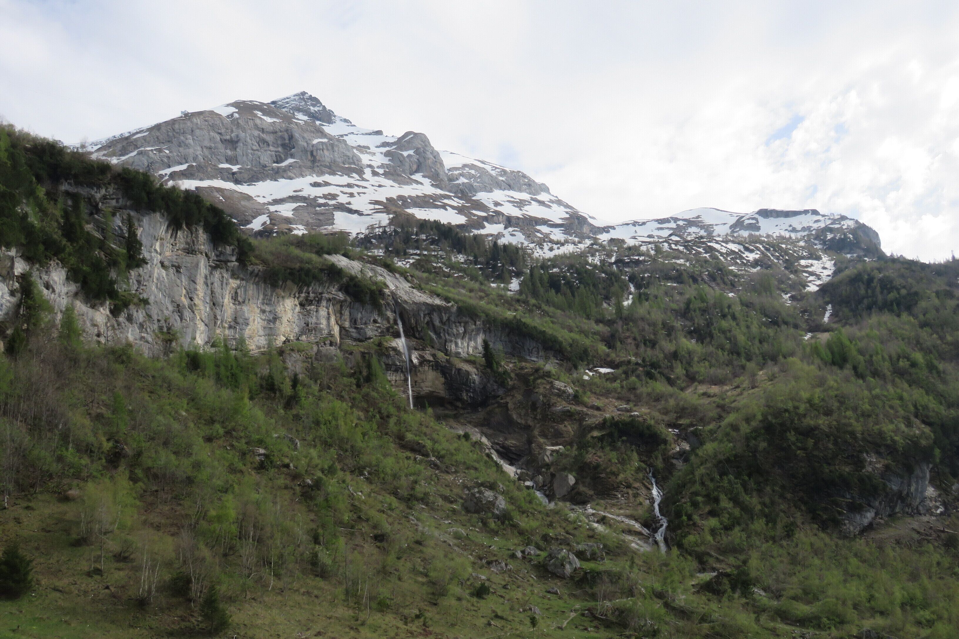 A mountainous landscape with rocky cliffs and a waterfall.