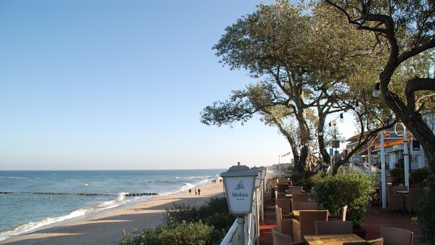 Een restaurant aan zee met terras, met uitzicht op het strand.