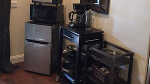 A compact kitchenette with a refrigerator, microwave, coffee maker, and a small cart with storage baskets. - Room 4 Two in Montecito/ Santa Barbara (Montecito)