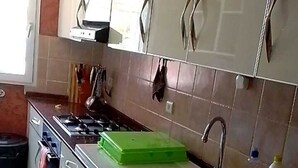 A kitchen with white cabinets, a stove, and a sink. - Saly: House / Villa - Saly (Saly)
