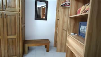 Ein schmaler Flur mit Holzausbau, einer kleinen Bank und einem Spiegel an der Wand.