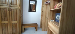 A narrow hallway with wooden cabinets, a small bench, and a mirror on the wall. - Saly: House / Villa - Saly (Saly)