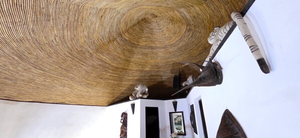 A room with a wooden ceiling, a tiger statue, and a framed picture on the wall. - Saly: House / Villa - Saly (Saly)