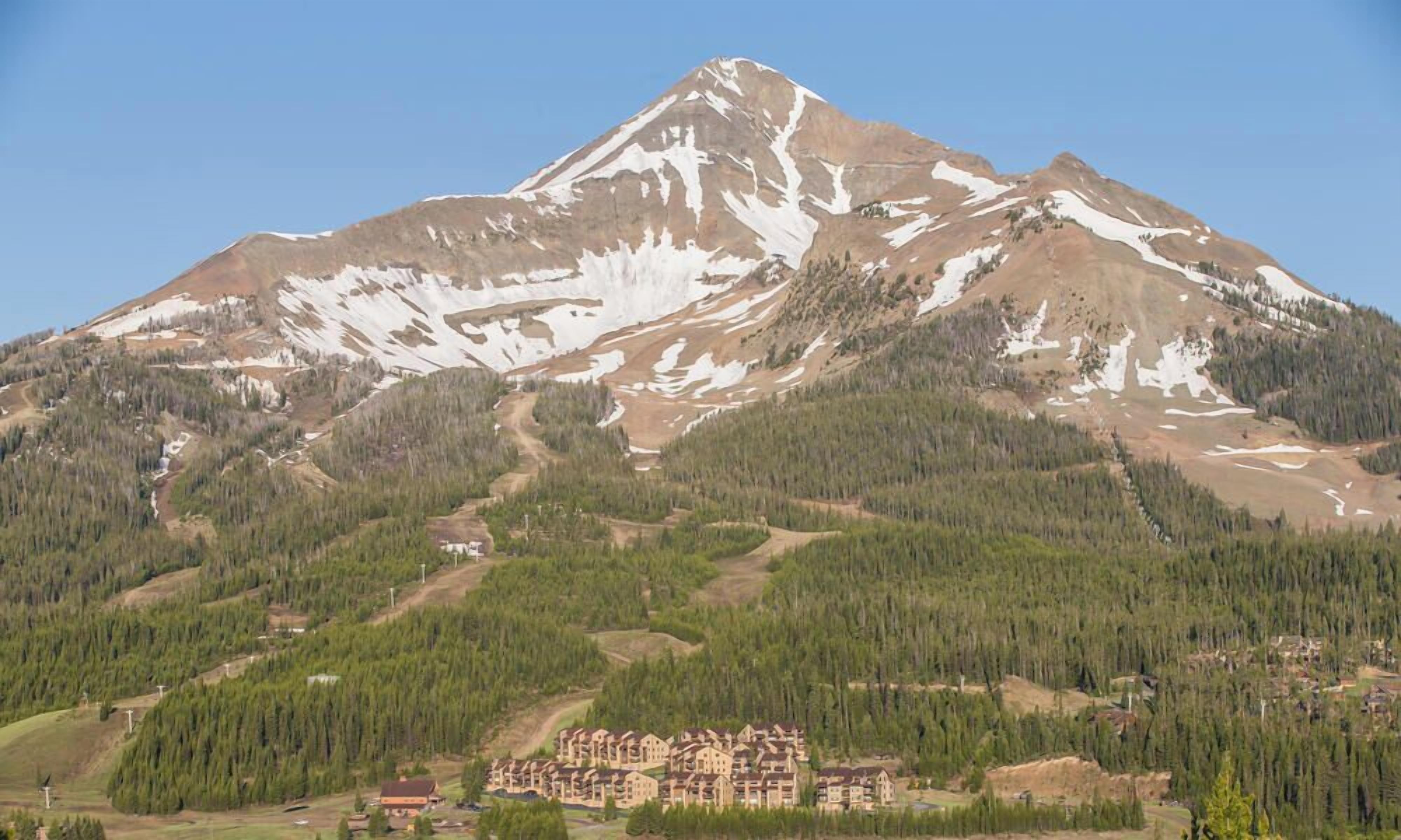 A mountain with a ski resort and a lodge with multiple buildings.