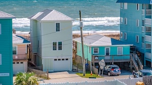 Zona residencial costera con casas, un garaje y vista al océano.