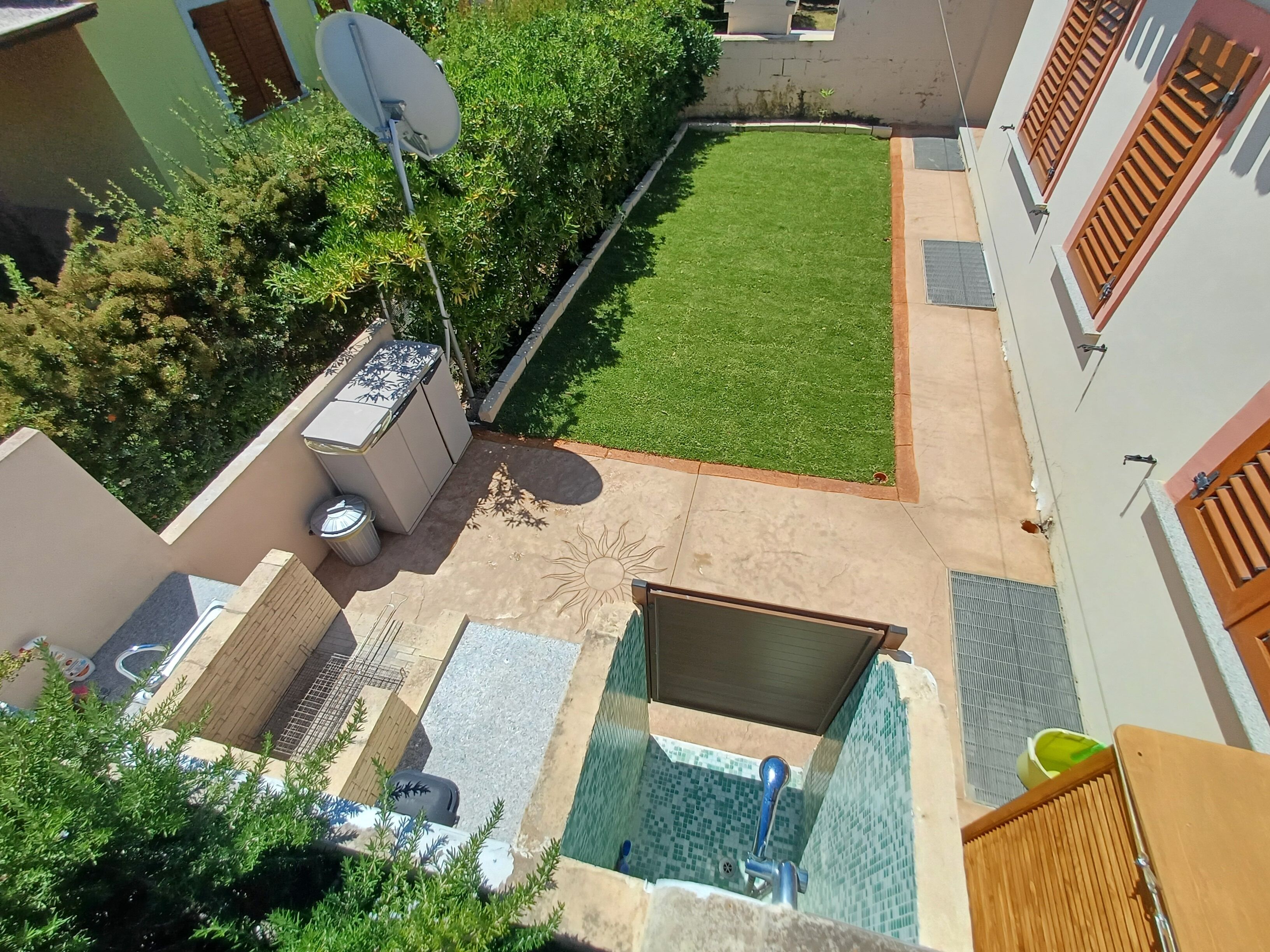 Ein Wohngebiet mit Schwimmbad, kleinem Garten und Satellitenschüssel.