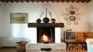 A cozy living room with a fireplace, a television, and a rustic wooden ceiling. - Villa in a panoramic position in San Gimignano (San Gimignano)
