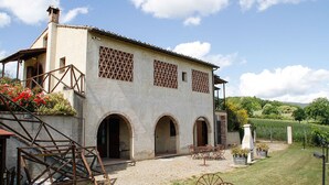 A building with a courtyard, arched doorways, and a staircase. - Villa in a panoramic position in San Gimignano (San Gimignano)
