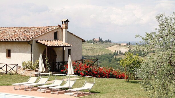 A villa with a swimming pool, lounge chairs, and a view of rolling hills. - Villa in a panoramic position in San Gimignano (San Gimignano)