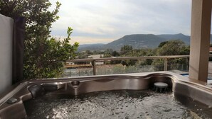 Un bain à remous avec vue sur les montagnes et les arbres.