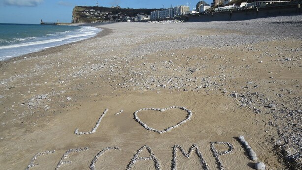 Ein Strand mit den Schriftzügen 'I ♥ CAMP!' aus Steinen und 'CAMP' im Sand.