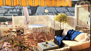 An outdoor seating area with a table, chairs, and a wicker sofa. - Viuter - Marina Vista Puerto Rico (Mogán)