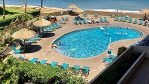 A resort pool area with a circular pool, lounge chairs, and palm trees. - Royal Kahana 318 Studio Bedroom Condo by RedAwning (Lahaina)