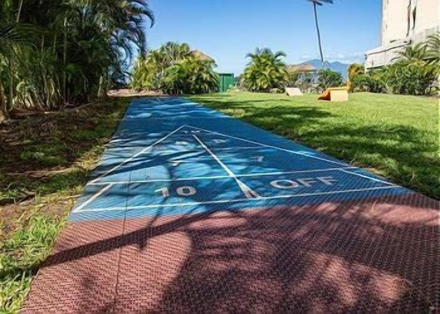 A shuffleboard court with a blue surface and numbered scoring areas.