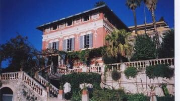 Un grand bâtiment à deux étages, doté d’un balcon et d’un escalier menant à l’entrée.