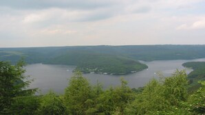 Vista panorámica de un río rodeado de colinas y vegetación densa.