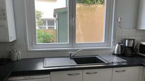 Une cuisine équipée d’un évier, d’une fenêtre et d’un lave-vaisselle.