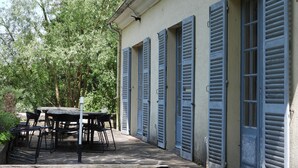 A building with blue shutters, a table with chairs, and a garden area. - House nest in the forest, near castel Compiègne, Pierrefonds and Chantilly (Saint-Jean-aux-Bois)