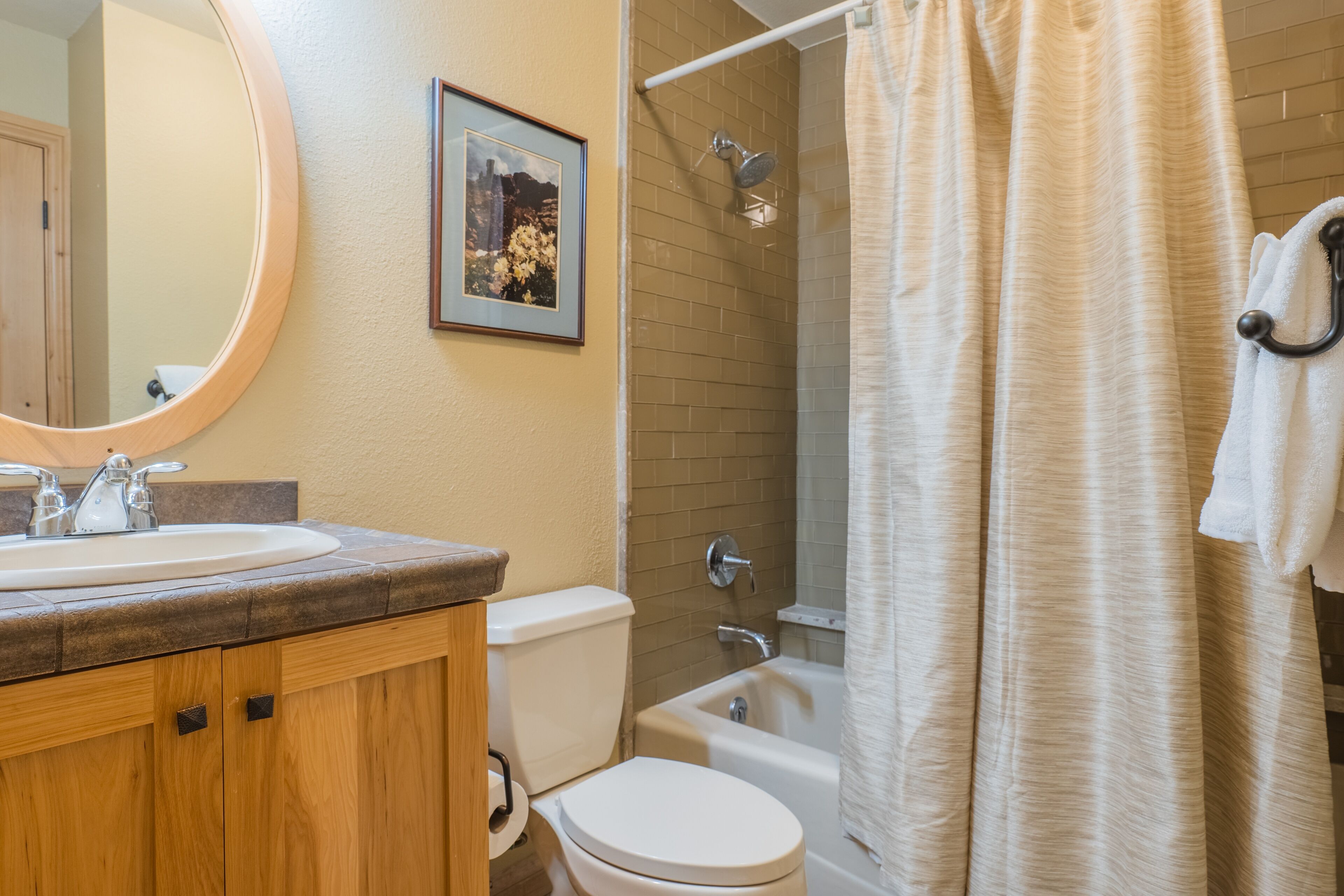 A bathroom with a sink, toilet, bathtub, and shower curtain.