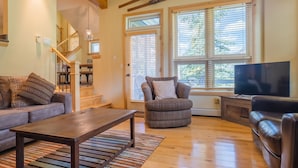 A living room with a sofa, armchair, and TV, wooden floors, and a staircase. - Private Home With A Beautiful Mountain Vista - Woods24 by RedAwning (Copper Mountain)